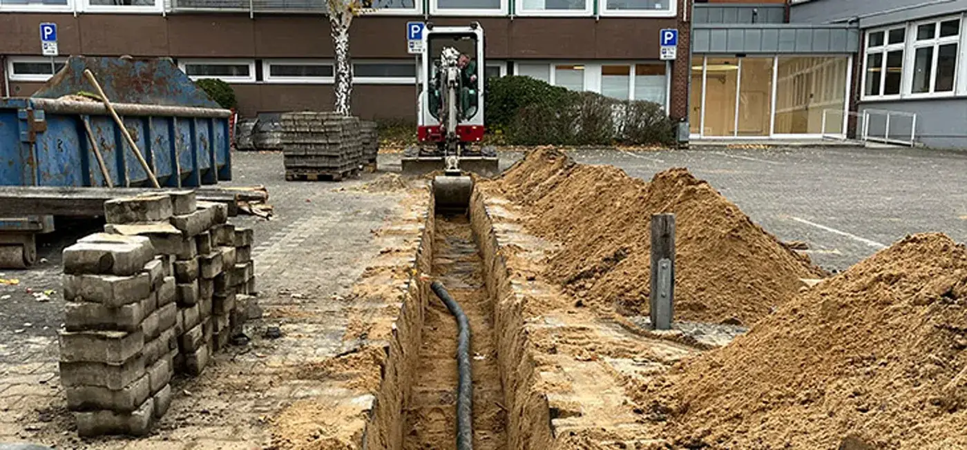 Offener Kabelgraben mit Schutzrohren im Straßenraum